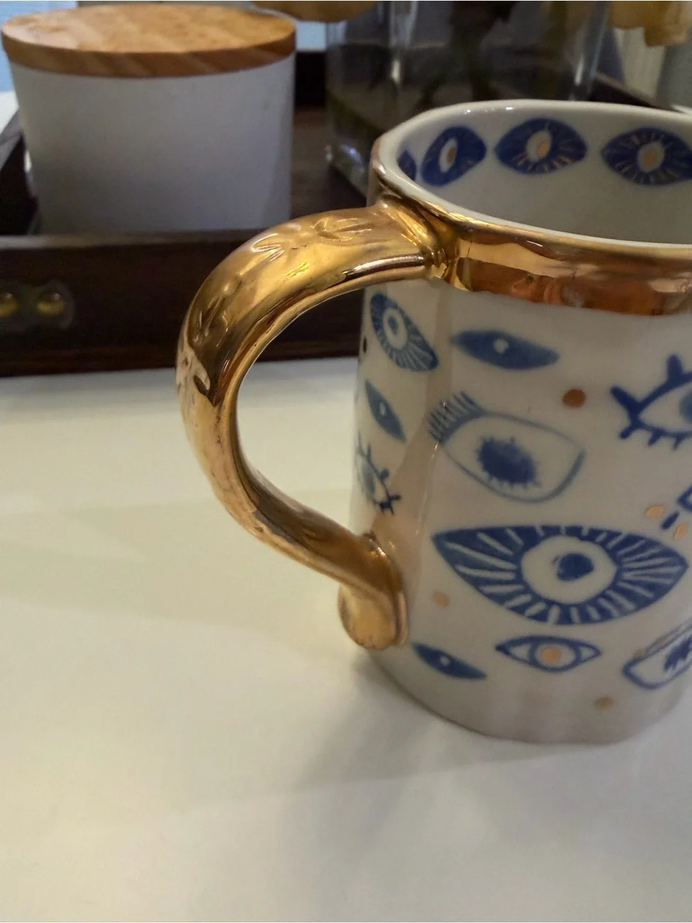 Anthropologie White Ceramic Mug with Blue Eye Motif and Gold Trim